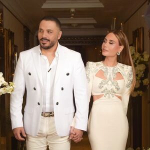 Ramy Ayash Instagram - رامي عيّاش.. يتزوج مرة ثانية !
 لينك الفيديو في البايو 

لم تكن الذكرى السنوية العاشرة على زواج البوب ستار "رامي عيّاش" كسواها ، هو الذي يقدم دوماً تحف فنيّة استثنائية، حضرت هذه الليلة الحالمة ليتغنى رامي بأفكاره الخلاقة ويأخذنا معه الى عالمه بمشهدية قلّما يقال عنها ملكية بلمسات راقية.
رامي الذي أراد ان يخلد هذه الذكرى السعيدة مع محبيه، فاجىء زوجته مصممة الأزياء داليدا عياش بعد عشاء متواضع وخاص مع العائلة في فندق هيلتون حبتور  بمناسبة عيد ميلادها الذي حوله الى حفل زفاف أدهش به داليدا والجميع . 
وتكلل الحفل اطلالة ملكية لداليدا  اختارها لها مصمم الازياء العالمي زهير مراد الغالي على قلب داليدا، بفستان ابيض تناسب تماماً مع هذه الليلة الحالمة كان بانتظارها في الجناح الملكي مع فريق عمل جاهز لتغيير الماكياج مع افون ابي حاتم  والشعر مع وديع  شليطا وفادي عواد . 
وبتنسيق مع الماركة الأحب الى رامي وداليدا روسونيرو ميشال زغيب ، اختار رامي خاتم بتصميم خاص يقال انه من أجمل تصاميم الماركة العالمية وهو الحجر واللون الاحب على قلب داليدا الاميرالد مرصع بالألماس اشبه الى الخيال.
ولدى دخولك الى الصالة المزدانة بأنامل منسق الحفلات وليد باز "باز ايفينت "، تلفتك فخامة الديكور والورود التي تحيط بك كيفما نقّلتَ نظريك.. حيث انتظرهم الأصدقاء والأحباب والعائلة ليستقبلوا العرسان، ولم يكتف رامى عياش بذلك انما خصها بأغنية من اللهجة اللبنانية وهى "يا مراية بيتى" زخرفها بألق وجده وعشقه من ألحانه وكلمات الشاعر مازن غنام وتوزيع الكسندر ميساكيان.. واختتم الحفل بسهرة فنية مميزة مع محبيه الذين رفضوا إلا ان يشاركوه فرحته.