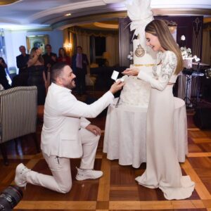 Ramy Ayash Instagram - رامي عيّاش.. يتزوج مرة ثانية !
 لينك الفيديو في البايو 

لم تكن الذكرى السنوية العاشرة على زواج البوب ستار "رامي عيّاش" كسواها ، هو الذي يقدم دوماً تحف فنيّة استثنائية، حضرت هذه الليلة الحالمة ليتغنى رامي بأفكاره الخلاقة ويأخذنا معه الى عالمه بمشهدية قلّما يقال عنها ملكية بلمسات راقية.
رامي الذي أراد ان يخلد هذه الذكرى السعيدة مع محبيه، فاجىء زوجته مصممة الأزياء داليدا عياش بعد عشاء متواضع وخاص مع العائلة في فندق هيلتون حبتور  بمناسبة عيد ميلادها الذي حوله الى حفل زفاف أدهش به داليدا والجميع . 
وتكلل الحفل اطلالة ملكية لداليدا  اختارها لها مصمم الازياء العالمي زهير مراد الغالي على قلب داليدا، بفستان ابيض تناسب تماماً مع هذه الليلة الحالمة كان بانتظارها في الجناح الملكي مع فريق عمل جاهز لتغيير الماكياج مع افون ابي حاتم  والشعر مع وديع  شليطا وفادي عواد . 
وبتنسيق مع الماركة الأحب الى رامي وداليدا روسونيرو ميشال زغيب ، اختار رامي خاتم بتصميم خاص يقال انه من أجمل تصاميم الماركة العالمية وهو الحجر واللون الاحب على قلب داليدا الاميرالد مرصع بالألماس اشبه الى الخيال.
ولدى دخولك الى الصالة المزدانة بأنامل منسق الحفلات وليد باز "باز ايفينت "، تلفتك فخامة الديكور والورود التي تحيط بك كيفما نقّلتَ نظريك.. حيث انتظرهم الأصدقاء والأحباب والعائلة ليستقبلوا العرسان، ولم يكتف رامى عياش بذلك انما خصها بأغنية من اللهجة اللبنانية وهى "يا مراية بيتى" زخرفها بألق وجده وعشقه من ألحانه وكلمات الشاعر مازن غنام وتوزيع الكسندر ميساكيان.. واختتم الحفل بسهرة فنية مميزة مع محبيه الذين رفضوا إلا ان يشاركوه فرحته.