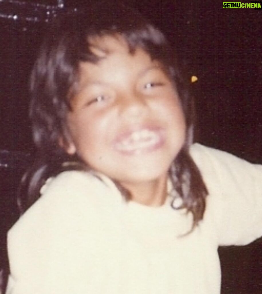 Sara Ramirez Instagram - Pic of Sara, at around 8 years old, wearing a light yellow shirt, a huge smile, and an early 80s mullet. Second pic is of 2 books; Sara’s extra flowery “This is the Story of” baby book open to the Baby’s Arrival page with birthday info, and the very serious looking Fathers Labor Coaching Log and Review Book because 1975. There is so much to say but I’m gonna keep it simple. You’re welcome. Happy birthday to me! May this kid continue to feel and know that they are loved beyond their gender, they are valued beyond their productivity, and they will always be held and protected by this softening blossoming adult who may or may not be bringing their killer mullet back.
