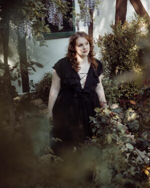 Shannon Purser Instagram - O October! Blanket me in auburn leaves and dappled sun. Speak to me in spectral winds and warm spice. Let me be not afraid of the darkness. Let me welcome the unknown to my hearth as an old friend and take its hand. Let the whispering ghosts both ancient and new come to greet me. I am a wandering spirit just like you. 🕸⚰️🖤🎃

•photos: @susieq•
•hair/makeup: @blondiewoodbeauty• 
•clothing/location: @michelinepitt @la_femme_en_noir_•