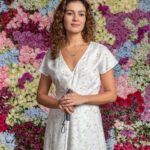 Sophie Charlotte Instagram - Hoje é a estreia de Todas as Flores , novela original @globoplay ! O primeiro capítulo será transmitido em uma live na plataforma, aberta para não assinantes, às 20h. A transmissão da novela escrita por João Emanuel Carneiro com direção artística de Carlos Araujo será feita por dois sinais diferentes, o primeiro com áudio original e o segundo com o recurso de audiodescrição. Os demais quatro capítulos do primeiro bloco ficarão disponíveis na sequência e toda obra entrará no catálogo com e sem audiodescrição, sempre às quartas-feiras. A primeira fase da trama contará com 45 capítulos, até o dia 14 de dezembro, e a segunda fase será disponibilizado no primeiro semestre de 2023. #paratodosverem na primeira foto estou caracterizada de Maíra , cabelo solto cacheado, um vestido transpassado leve branco com estampa de folhagem clara, tênis offwhite, e bengala. Na foto seguinte estou com o mesmo visual , ao lado das personagens : Judite (Mariana Nunes) , Zoe ( Regina Casé) e Vanessa (Letícia Colin) . Cada uma na intenção de seu personagem. O fundo de ambas as imagens é uma linda parede de Flores Naturais , rosas brancas e rosas pink , hortênsias, gerberas, orquídeas etc.
