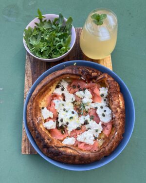 Annabel Crabb Instagram - Breaking: There is now a very satisfying nuclear escalation going on among my children re breakfast in bed. My 17yo, a naturally competitive tyke, learned of yesterday’s fish finger sandwich delivery by her puny sibling and has returned serve blisteringly with this Dutch Baby featuring smoked salmon, whipped cream cheese w capers, cornichon, thyme, lemon zest, green olives and served with a rocket salad and an apple and elderflower spritz on the side. All just ridiculously delicious… all eyes on the 14yo now. And on the 11yo who is away on a sleepover and will shortly return to find her palace of breakfast dominance memorably ransacked OMG. Swipe for further plating photography also the moment last night when - going to bed - I formally acknowledged that the book pile is getting a bit too tottery.