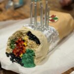 Annabel Crabb Instagram - JUST LOOK at the burrito cake @glamgwenblake made at the request of her daughter. The corn is made from chopped up banana lollies. The silver foil is EDIBLE. The rice is rice bubbles tossed in melted white chocolate. A thing of delight. Happy birthday Honor. ❤️ ps this is Gwen’s photo, I took a bunch but none of them came out as nicely as Gwen’s for reasons that should be obvious haha. @chat10looks3