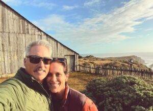 Annabeth Gish Instagram - Two decades ago today, we stood on the rugged and wild cliff-edge of the Sea Ranch Lodge to get married. The sky was exquisitely blue, the temperature a typical Northern Cali October brisk. Friends and family surrounded us, and we said things no one else could hear because the wind carried them out to the sea. Then we had the best party we’ve (still!) ever been to—though how is it our wonderful sons weren’t there!?! Twenty years later, to return and stand on the same ground is humbling. The elements have not changed in their persistence. The barn is more weathered, the coastline more ocean-carved, and windswept. Lol, so are we. Life works hard on us all. But what a brilliant adventure! What gratitude lives in our hearts. Happy Anniversary @donutshoppeproductions