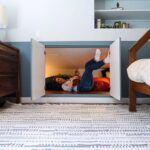 Ashley Williams Instagram - “My name’s Gus and I like small spaces,” my nine year old used to introduce himself to people this way. He loves reading, drawing, and “being cozy,” so when we considered designing a bedroom for him, the only answer was this mahogany treehouse vibe. We went to @roomandboard and had the best time designing exactly to his sensibility. He loves to sit at his desk and “imagine that I’m in the forest.” I’m obsessed with Room and Board’s sturdy, clean lined aesthetic and sometimes on stressful days I go hide in there myself. 😆 #homerenovation #kidsroom @we_are_kismet @alchemy_collective_ #roomreveal #ad