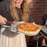 Briony May Williams Instagram - We’ve just got back from Italy and are missing the epic pizzas so we’ve been trying out our new @cuisinart_europe indoor pizza oven (we popped it outside as it’s a beautiful day!) on this glorious summer afternoon ❤️ It. Is. AMAZING!!! My bro went down to @thedoughkitchenbristol to get the delicious sourdough dough balls for the bases then we topped them and had crispy deliciousness in minutes!!! Thank you so much Cuisinart 🍕#gifted #giftedproduct #pizza #pizzaoven #homemadepizza