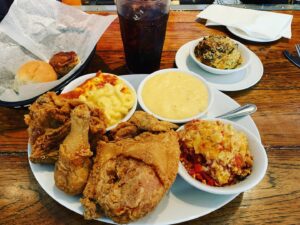 Carolyn Hennesy Instagram - I was going to get it to go...but thought better if it. @marymacstearoom #marymacstearoom clockwise from top.  Broccoli soufflé, tomato pie, bird, Mac n cheese.  The cheese grits are already gone.  That’s a cinnamon roll. It’s everything...ever. #greatfood #bliss #atlanta #makingmovies