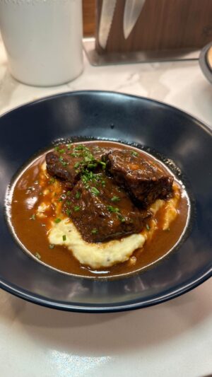 Cassie Yeung Instagram - Reservations or a home cooked meal or we leave him alone 🌹🥀

3 lbs short ribs
1/2 large onion, roughly chopped
3 celery stalks, roughly chopped
3 medium carrots, roughly chopped
2 tbsp tomato paste
1/2 bottle of red wine (I used Merlot)
2-4 cups of beef broth
1 head garlic, halved
Bundle of thyme & rosemary
3 bay leaves 
Salt and pepper to taste 
1 Tbsp butter 

Preheat oven to 350
Season short ribs generously on all sides with salt and pepper, then sear in a Dutch oven with neutral flavored oil until each side has a nice color. You may want to do this in a few batches to avoid overcrowding the pot. 
Remove the short ribs then add in celery carrot and onion. Season with salt and pepper and cook and cook for 5 minutes or until they become slightly translucent. Add in tomato paste and cook until lightly toasted. Pour in wine, bring to a boil and allow to reduce slightly. 
Add short ribs back in along with garlic, herbs, and enough beef broth the cover. Bring to a boil then cover with a lid and transfer to the oven for 2 hrs or until falling off the bone and fork tender. **if you don’t have a dutch oven, simmer in the stove for 2.5 hrs, pressure cook on high for 1 hr, or slow cooker for 8 hrs. 
Remove short ribs and strain veg and herbs out of the braising liquid. Bring up to a boil and allow it to reduce and thicken. Cut the heat and add a tablespoon of butter. 
Serve short ribs over a bed of mashed potatoes and pour a generous serving of sauce over. Finish with chive razzle dazzle and enjoy lovers!!