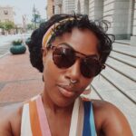 DeWanda Wise Instagram - Lately. {De outside in a cute striped dress, shades, and earrings with her septum piercing in. Bywater. A sign reads, “Beware of Ghosts.” My skincare routine is water, sunscreen, and minding the business that minds me. Pizza that’s hilariously large to be on the kids menu. A long hallway with her dog.}