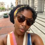 DeWanda Wise Instagram - Lately. {De outside in a cute striped dress, shades, and earrings with her septum piercing in. Bywater. A sign reads, “Beware of Ghosts.” My skincare routine is water, sunscreen, and minding the business that minds me. Pizza that’s hilariously large to be on the kids menu. A long hallway with her dog.}