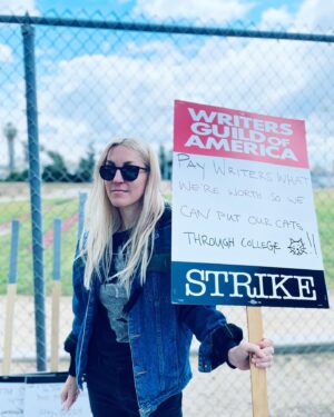 Dylan Meyer Instagram - You may not know this but we (the writers) have struck because The Man is trying to get us down. Without writers, your movies and tv shows will suck. Trust. Our fight for fair wages is so important we’ve been forced to walk around and wave signs about it - and we need your support! If you love stories tell the studios to value the storytellers! #wgastrong writers 4 ever PS doesn’t @kiwilovesyou’s incredible jumpsuit go great w my sign?!?