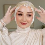 Gözde Akyıldız Instagram - Güzeller güzeli @akyldzgzde ‘yi hazırlamaktan büyük mutluluk duyduk!✨ Her gelinimize yaptığımız gibi yüz hatlarına uygun olarak, özenle seçtiğimiz renklerle ve aksesuarlarla makyaj ve türban tasarımını tamamladık🤍 Gelinlik: @houseofzarif Aksesuar: @gizemyolcustudio #türbantasarımı #gelincicegi #gelinçiçeği #gelinbaşı #gelin #gelinlik #gelinaksesuarı #gelinbuketi #gelinmakyajı #gelinlikmodelleri #gelinbasimodelleri #gelinbaşıtesettür #davetiye #nikahelbisesi
