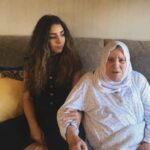 Gina Dirawi Instagram - Jag har alltid olivolja i mitt badrumsskåp. Det är min farmor Fatimas fel. När jag var liten brukade hon tvinga mig titta på medan hon oljade håret och flätade olivoljeflätor. Oljan läker allt, sa hon. Också det som gör ont. De hade kvinnorna innan henne vittnat om. Fatimas lägenhet i Sundsvall var ett heligt tempel tillägnat olivolja. Små fat, bräddfulla av flytande guld,prydde varje vrå, och medan hon följde världens händelser på TV:n såg jag olivoljeflätorna få liv. De vävde en historia om en ung tjej vars svett och arbete färgade olivlundarna. Om nätter tillbringade under olivträdens stjärnbelysta himlavalv. I varje droppe såg Fatima ett kalejdoskop av minnen, ett helt universum osynligt för mina ögon, och som liten flicka grep jag desperat tag vid varje tillfälle att se henne måla liv i de delar som redan då fattades mig. Häromdagen stod jag och oljade håret i över två timmar. Det kanske låter överdrivet, men sen hösten har tiden jag spenderat med oljorna ökat. Minuter har förvandlats till timmar. Jag smörjer och smörjer, kroppen och håret. Kammar och flätar, och tänker på henne. På allt hon fick säga och allt som tystades ner. På hur hon fick sörja och hur hon förnekades sin sorg. På allt som togs ifrån henne och allt hon vann, och hur jag ser konturerna av henne även i det här: Att se klipp på youtube på sitt hemland och längta, titta på olivolja och längta, fläta sitt hår och längta. Jag är så jävla trött på att längta. Trots det återvänder jag till oljan och flätorna. I varje drag ger jag liv till en historia och ett arv som världen envist försöker tysta ner. Det blir ett litet manifest, som bara jag kan se. En tyst handling som sträcker sig flera tusen år tillbaka i tiden, som tydligen ska läka de allra djupaste såren. Ibland undrar jag om Fatima visste om att hon förberedde mig för de dagar då jag skulle behöva det som mest. Ritualer som läker det onda, det har jag farmor att tacka för🤍 📸: @daniel_stigefelt