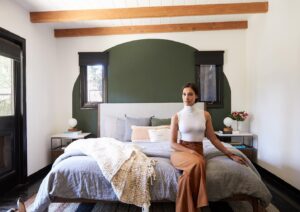 Janina Gavankar Instagram - The ceiling used to be painted silver. You can see these beams get shaved down to their natural color in my “house redo” highlight. (I can’t believe I almost did it myself. Thank god @mandychengdesign didn’t let me.)
As for this look - I know I present high femme at events, but I feel more at home in a more masculine/gender neutral environ. Probably why the central color of my house is army green. 
Also, I’ve never had a king bed. We chose this @inmod one Bc it’s modern and can be redressed a billion different ways as I inevitably change my mind about its coverings.
