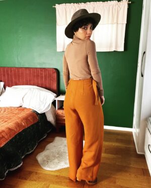 Jasika Nicole Instagram - These #MitchellTrousers by @closetcorepatterns are such a welcome addition to my pattern stash- I have a lot of great slim fit trousers in my arsenal but way less chic wide legged patterns to play around with and I absolutely love this cool, funky silhouette! I’m feeling a little Annie Hall pairing these pants with this hat (RTW from a leather and hat store in Santa Fe); if I just had a little vest to throw over this true bias turtleneck I would be set! The @wearethefabricstore fabric is 🥹🥹🥹 exceptional. It’s a heavyweight viscose twill in pumpkin and I’ve never sewn with anything quite like it. It somehow manages to be thick and squishy while also feeling floaty and hanging fluidly. You ever go to a really high end store or like, a Bloomingdale’s, and thumb through the really expensive garments and wonder “what the hell kind of fabric is this??” because it’s THAT luxurious? This is the fabric they are using lol. I would get it in every color if they had more! One important thing to know is that this fabric must be handled with care- despite its heaviness, it’s surprisingly delicate and it does not like lots of pin holes or the fabric will snag. It requires extra attention but these pants were worth every ounce of care I put into them. As always, the pattern is thoughtful with interesting details (the adjustable side ties!!!) and I can’t wait to make a lighter weigh pair for warmer months! Oh, and outfit also features my new fanny pack from @imadethatbag - I am over the moon in love with it and have used it every single day since I bought it. Lots of great styles, you can request different leather, the pouches are removable so you can choose different colors to match your fit, and it’s beautifully made- thrilled to spend money at a small woman owned business like Lorna’s! ❤️❤️❤️