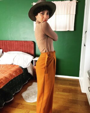 Jasika Nicole Instagram - These #MitchellTrousers by @closetcorepatterns are such a welcome addition to my pattern stash- I have a lot of great slim fit trousers in my arsenal but way less chic wide legged patterns to play around with and I absolutely love this cool, funky silhouette! I’m feeling a little Annie Hall pairing these pants with this hat (RTW from a leather and hat store in Santa Fe); if I just had a little vest to throw over this true bias turtleneck I would be set! The @wearethefabricstore fabric is 🥹🥹🥹 exceptional. It’s a heavyweight viscose twill in pumpkin and I’ve never sewn with anything quite like it. It somehow manages to be thick and squishy while also feeling floaty and hanging fluidly. You ever go to a really high end store or like, a Bloomingdale’s, and thumb through the really expensive garments and wonder “what the hell kind of fabric is this??” because it’s THAT luxurious? This is the fabric they are using lol. I would get it in every color if they had more! One important thing to know is that this fabric must be handled with care- despite its heaviness, it’s surprisingly delicate and it does not like lots of pin holes or the fabric will snag. It requires extra attention but these pants were worth every ounce of care I put into them. As always, the pattern is thoughtful with interesting details (the adjustable side ties!!!) and I can’t wait to make a lighter weigh pair for warmer months! Oh, and outfit also features my new fanny pack from @imadethatbag - I am over the moon in love with it and have used it every single day since I bought it. Lots of great styles, you can request different leather, the pouches are removable so you can choose different colors to match your fit, and it’s beautifully made- thrilled to spend money at a small woman owned business like Lorna’s! ❤️❤️❤️
