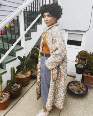 Jasika Nicole Instagram - I didn’t hop onto the quilted jacket trend til @byhandlondon released the #NerrisaCoat pattern a couple months ago. I loved the collar, the oversized fit and the long length, three elements that I had not previously seen in quilted coat patterns, and I had the *perfect* fabric for it- a geometric reversible quilted cotton smack in the middle of my color palette from @corefabrics. The pattern is very simple, pretty beginner friendly, and requires very little fit adjusting because it’s so oversized. I made the smallest size available (it goes up to a size E/ 61.75” bust) but it’s still incredibly roomy, like I could probably fit a sweater AND another coat under this lol. If I were to make it again I would probably slim down the fit by a couple inches and shorten it to shin length, which I might still do, but I wanted to get some wear out of this length before I chopped it up. I opted not to add buttons to the front and just have this be a kind of open jacket for layering. I made the bias binding myself and this is the only issue I had with the pattern- it says you need 5 meters of binding but I easily used 3 times that much for this view (I stopped counting after the third time I had to pull out my tools to make more tape 😵‍💫), so maybe that amount was meant for the shorter version of the jacket (because it doesn’t give different amounts for the different views). Thankfully I had just enough tencel scrap fabric to make all the tape I needed. The bias binding gives the jacket a nice pop of color while still feeling a bit neutral and I love how the colors in the fabric and tape play off of each other. I’m on the fence about the patch pockets on my version and think it would look even better with inset pockets, and because of the bulk of the quilted fabric, the drop sleeves look a little funky at the seams(I prefer inset sleeves). But those design choices are what makes this such a simple and quick pattern to finish, and I’m still happy with how this came out. The fabric is structured but soft and wearing it feels like you’re draped in a blanket cocoon- it actually makes a pretty great housecoat if you’re careful to not trip over it 😂