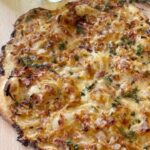 Judy Joo Instagram - I had to develop a French recipe for comedian Joe Wilkinson @gillinghamjoe on Cooking with the Stars. Thus, this tasty Tarte Flambée (Flammkuchen) recipe is really easy, quick and gloriously tasty. 🇫🇷 I over engineered the recipe, so it would be super easy for Joe to make. The dough is the measured amount to the exact size of a half sheet pan, to roll to the correct crispy thinness that you want in this pizza like tarte… This classic dish from Alsace is known for its thin, crispy base, and a tasty savoury topping of smoky bacon, Emmental cheese, and sweet caramelised onions. I also like to add fresh thyme leaves for a welcomed bite of fragrance and herbiness. 🥓🧀 - Use high quality extra virgin olive oil in your dough. It’ll give your crust that crunch and flavor. - Use good quality smokey bacon and finely dice it so every bite gets its fair share. - Stick with Emmental for your cheese. Its creamy texture and mild flavor make it the sidekick for your bacon and onions. - Add a little sprinkle of fresh thyme and a grating of nutmeg. Trust me, your taste buds will thank you. - To wash down your scrumptious Flammkuchen, whip up an Alsatian wine spritz. 🍸 It’s a refreshing blend of gin, Alsace gewürztraminer, lemon juice, and golden syrup (or honey). Served with a side salad loaded with baby spinach and rocket, it’s the perfect balance. 🥗 Head on over to the link in my bio 🙌 • • • • #chef #foodie #cooking #foodlove #foodart #foodblog #foodculture #delish #foodiegram #instafood #frenchfood #recipe #homecooking #flammkuchen #alsace #winespritzer #salad #bacon #emmental #cheese #onion #thyme #nutmeg #tarteflambee #chefsofinstagram