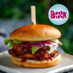 Judy Joo Instagram - Happy Sunday! 🙌 Perfect time to share a recipe highlight from my @SundayBrunchc4 appearance, where I made my famous Korean Fried Chicken Sandwich-- just like the one we sell @seoulbirduk. This is not just a sandwich, it's an experience. Extra crispy on the outside, and deliciously juicy on the inside. Let me walk you through it. 🍗🇰🇷 For the chicken precoat: 30g cornflour/starch 2½ tsp sea salt ½ tsp baking powder Freshly ground black pepper 6 chicken boneless skinless thighs or breasts Mix together salt, cornflour, baking powder, and pepper. Toss the chicken pieces in the mixture to cover, shaking off any excess. Place chicken on a wire rack to keep dry. For the Batter: 64g cornflour/starch 20g fine matzo meal 30g plain flour 2 tbsp Korean chilli flakes (gochugaru) 1 tbsp sea salt 2½ tsp garlic powder 2½ tsp onion powder ¼ tsp baking powder 90ml vodka Mix together all of the above ingredients and add just enough cold water to make the consistency like paint, like a thickish slurry. For the BBQ sauce: 3 tbsp Korean chilli paste (gochujang) 3 tbsp ketchup 2 tbsp dark brown sugar 2 tbsp dark brown soy sauce 1 tbsp toasted sesame oil 2 tsp grated peeled fresh ginger 2 garlic cloves, grated or finely chopped Mix all of the above together in a small sauce pan, bring to a simmer over low heat, allow to cook over low heat for about 3 mins while whisking (do not let burn). Remove from heat, set aside. For the Sandwich: 6 potato buns, split, buttered, and toasted (or pan fried, flat side down) 6 tbsp kewpie mayonnaise ½ head iceberg lettuce 6 slices red onion or tomato 250g cabbage kimchi, diced Dip the precoated chicken into the wet batter and immediately fry in oil at 350F / 180C. If you want to double fry (extra crispy) do the first fry at 300F/150C, allow chicken to rest then do the second fry at 350F/180C until bronzed. Spread bun with mayo, place chicken in, slather with bbq sauce, top with lettuce, onion, kimchi, top bun and enjoy. What recipe would you like to see next? Let me know in the comments! And don't forget to visit my website for more delicious recipes. #KoreanFriedChicken #SundayBrunch