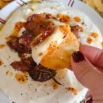 Laura Vitale Instagram - Y’all have you whipped up some brie and topped it with unbelievably crispy sweet sticky rosemary infused bacon and drizzled with chili oil and kissed by a touch of honey?!!! No?!!! WHAT ARE YOU WATING FORRRRR?! Seriously though, it’s sublime and so easy!! Whip up some brie in a high powered food processor with a couple tbsp of milk (don’t use this little one like I did because I needed to switch to my big powerful one) and whiz it up until it’s creamy, smooth and decadent. Set it in the fridge for a few min while you bake the bacon. Add chopped bacon to a little oven safe dish, add about a tbsp or two of maple syrup (I used about 6oz of bacon for this batch) a good sprinkle of bbq seasoning (I buy mine) or any seasoning you like along with a little fresh rosemary and bake at 375 about 15ish min or until crispy. Plate the Brie in a shallow bowl, top with the crispy bacon then drizzle some chili oil (I used TJ brand) and a little drizzle of honey and served it with crackers. MY LAWDDDSDDDD ITS SENSATIONAL!!! Must make!!