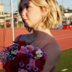Lily Brooks O’Briant Instagram – When your sister comes in clutch & helps sneak you onto the football field at her HS for a photo shoot 🤫 
•
Thank you so much @prompartyshop for letting me use these beautiful dresses for the shoot! & a huge thank you to @ja.photographic & @lo.photographic for these incredible photos! 💐✨
•
•
#singer #newsong #newartist #newmusic #seventeen #17 #singersongwriter #music #musician