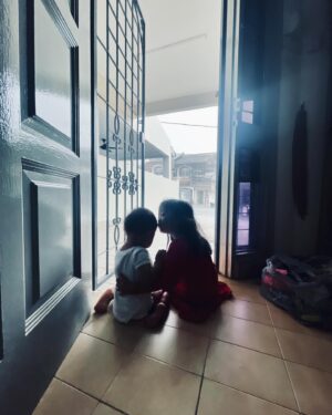 Nadia Aqilah Instagram - I was (as usual) kelam kabut nak prep stuffs in out up and down then suddenly i caught these two just sat there. Calmly. Secretly captured this beautiful moment. 

Senja : “Mama, we are listening to the rain. Come!” 
Then I realised. We taught our daughter just that since she was born. Listen to the rain, smell the sun, look at the clouds, step on the grass. Tapi, do we, as adults, do it enough? 

My babies. What do I do without you. Thank you Senja,  for reminding me to just breath. Awak ni kan, haih. We sat there for a good 15 min sampai Baba came back home. 

Apa pun, Salam Zulhijjah everyone ❤️ Jangan lupa berdoa setinggi gunung minggu ini, terutama buat saudara kita di Palestine ⭐️