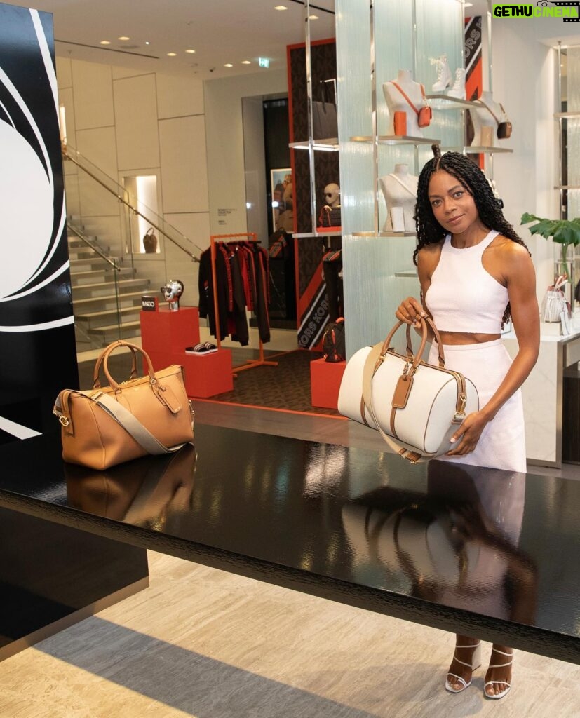 Naomie Harris Instagram - What a whirlwind the last 48 hours have been! Flew to London to visit the Regents Street flagship @michaelkors store, and help with the launch of the fabulous #mkcx007 Bancroft bag! Then stopped by the pop up @omega store at the Burlington Arcade to preview the latest collection of Bond related watches! A quick outfit change and onto the red carpet for the Bond premiere! Followed by a few hours sleep and back on a plane to Spain to continue filming! Mental! But soooo much fun! Thank you @michaelkors for the stunning outfits, and thank you @omega for always providing the perfect accessory for any outfit!! Photographer credits: @mikemarslandphotos @johnallenphillipsphoto