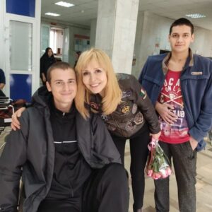Olga Kormukhina Instagram - Ещё днём хотела поставить этот пост. Но теперь он стал ещё актуальнее. Вчера сподобились петь для наших раненых бойцов в госпитале Бурденко. Всё прошло отлично! И девочки из нашей Академии прошли на «ура» и у бойцов, и у медперсонала ( в основном женского). Пели на улице. Так, чтобы видно и слышно было во всех корпусах тем, кому не стоит пока особо передвигаться. Для нас, конечно, это был экстрим моральный, но! Чего только в жизни не бывает!Но я не об этом хочу говорить. А о наших парнях. Которых не столько мы поддерживали, сколько они поддержали в нас веру в то, что у нас достаточно храбрых и честных мужчин, готовых нас защищать. Как Володя Перфильев из 234 полка 76-й десантно- штурмовой дивизии! Да, да! Той самой! Псковской! Родной! Вова так бренчал на костыле, сидя  на коляске, что мне было реагажно и без группы.)) Потом, уже в корпусе,когда я спросила у врачей, сколько ещё нашему ( уже нашему)) Вове долечиваться, Вова сказал, не дожидаясь ответа: -Давайте быстрее! Мне назад надо! К своим! 
Ещё он всё хотел мне рассказать про девчонок - бойцов, которых враги называют «ночными ведьмами» . Не успели. Надо было бежать на Красную площадь. Но мы ещё свидимся! И на параде Победы споём! Мы теперь с ним на связи! Родня практически). 
Вова был ранен на Херсонском направлении. И вывозили его, представьте! На УАЗике! Вот что он написал:
«Буханки нужны для эвакуации раненых. Он реально нужен. 
Про фермер скажу он нужен именно в данную сезонную распутицу».
И ещё! Для мотивации: 
«Спасибо большое вам, они спасут не мало жизней». 
На фото: Володя , его товарищ ( прячет раненую руку)  и наши «новые имена» Каролина Корсакова и Майя Сперанская.
🔻🔻🔻