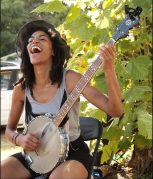 Rhiannon Giddens Instagram - Black Banjo Renaissance #20
Hannah Mayree and the Black Banjo Reclamation Project @hannah_mayree @black.banjo.reclamation 

The banjo spent many years being a center of spirituality for enslaved people of the African diaspora; throughout the years of minstrelsy and erasure, that connection has flowed underground like a unknown river, waiting for us to rediscover it - and we are.

Hannah Mayree formed the Black Banjo Reclamation Project to get as many banjos in black hands as possible. 

In Hannah’s own words (from an interview with Afropop):
“It goes back to what I was speaking on. And I am very much still on a journey with this. The banjo is taking me on a journey; it’s taking my local community on a journey. I’m just very excited to see where it takes us. The pain and trauma I was talking about, I think, is the pain of separation. It’s a very common emotion experienced by African-American people, expressed in different ways, when you lose trust in what you see and learn to question everything. I did not personally grow up knowing the banjo has its roots in the Black community. It’s bad enough what has happened all over the world to Black folks from health disparity, food apartheid, to prisons. For me to add “music” on top of that? Music is here to heal us!