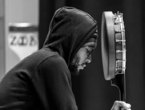Rhiannon Giddens Instagram - So it only seems fair to feature my actual banjo nephew on this, the day of his birth.  Justin Harrington, aka Demeanor @demxmusic, has been doing the impossible - combining clawhammer banjo, bones, beats and rap while advocating for rap as a folk form.  He attended the Black Banjo Gathering at age 5, where he received his first pair of bones from elder Cliff Irvin, and has since soaked up every bit of vibe from his aunt’s folk world and his own hip hop world. 

He is also a fierce organizer, being an important voice on the Greensboro scene for truth and justice.  His groundbreaking rap set at the Newport Folk Festival paved the way for Killer MIke, who is there this year, and he is active in the playback theatre scene in North Carolina; he also tours with Jake Blount (he is featured on that Tiny Desk). He is also a presenter and creator of the Underground Everywhere video series.  He is a young man to be proud of, even if we weren’t related.

Git it, Demeanor!

Pic by @karencoxphotography