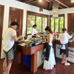 Rita Ferro Rodrigues Instagram - Dia 9 🐒 📞Chamadinha rápida para Portugal para vos contar as aventuras do dia de hoje em Phuket ! Saltámos da cama cedo para visitar a Old Town que esta cheia de vestígios portugueses ( sabiam que fomos os primeiros europeus a encontrar a Tailândia e que a relação entre os dois países é maravilhosa ?) A nossa pegada por aqui revela -se sobretudo na arquitectura sino- portuguesa de que é exemplo a casa onde funciona o restaurante/escola de cozinha Thai @blueelephant onde a fabulosa chefe @molly_007 nos ensinou a fazer dois pratos típicos. Os pintainhos estavam super atentos e adoraram passar a manhã a aprender mais sobre a gastronomia deste país que é riquíssima e deliciosa , aromática, doce e picante ao mesmo tempo - como a vida que todos desejamos! Do conforto do estômago para o conforto da alma, seguimos para Wat Chalong, local de peregrinação dos locais e de turistas tailandeses que chegam de todo o país para rezar e prestar homenagem aos monges fundadores deste templo ,que lideraram o povo na luta contra a rebelião chinesa em 1876, ajudando os combatentes a sarar as feridas , com as ervas medicinais que de forma sábia manipulavam. O calor hoje esteve muito intenso e por isso corremos à praia mais próxima para uma cacholada, vulgo, mergulhaça. O mar, hoje mais agitado , soube -nos bem! Um divertido braço de ferro salgado com as ondas mornas que nos rebentavam nas pernocas 🌊 Hoje vamos jantar ao @cafedelmarphuket e quem sabe até dançar um pouco 😎🪩💃🏽🕺🏻 Os pintainhos mais velhos querem conhecer a noite em Phuket e é bem possível que a mãe os envergonhe na pista de dança. Diz que há DJs uepá , vou com tudo , vão gastar os créditos de “cringe mãeeeee!!!”😂 Aos pintainhos nada a apontar. Essa é a verdade. À excepção do “ não ponham as toalhas molhadas em cima das camas” andam leves e felizes ( e tão queridos comigo 🥹) Bom, talvez nos vejamos nas stories mais logo, em modo dancing queen da ilha 🌴Amanhã, novo e último destino. O tempo passa demasiado depressa quando somos felizes. Até já ❤️ #SAii #SAiiscapes #SAiiLagunaPhuket @saii.lagunaphuket #bestravel #bestravelviagens