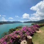 Rita Ferro Rodrigues Instagram – Dia 6 🤍
Como começar ?
Antes de chegarmos ao lugar mais bonito que os meus olhos alguma vez vislumbraram fizemos uma viagem de duas horas de barco – porque este lugar situa-se no Parque Nacional Khao Sok , província de Surat Thani (Tailândia) e inclui os 165 km² do Lago Cheow Lan contido pela represa Ratchaprapha. Deve ser aqui que habitam todas as divindades da natureza – só pode ser aqui o seu refúgio – pois não é possível tanta beleza existir sem um qualquer toque divino. Aguardámos pelo barco com uma futebolada com crianças locais,  fizemos a viagem com Sol, por entre várias tonalidades de água quente e doce que abraça escarpas magníficas e verdejantes, todas as cores da natureza em intensidade máxima, um espectáculo de poder do natural em bruto, uma parte do planeta muito preservada do toque humano. Chegámos ao @resort500rai  com uma tempestade tropical a aproximar -se, bela e breve, e os pintainhos loucos de alegria, aos mergulhos à chuva , um descontrole de emoções ( tão bom !) perante o cenário de sonho. Totalmente sustentável , este resort constituído por pequenas , simples e confortáveis casinhas de madeira, munido de painéis solares, caiaques ( só saímos dos quartos nestes barcos que estão atracados  à frente de cada habitação ) está totalmente integrado no parque natural. A partir das 22 h exige -se silêncio, o lema é “ disconnect to connect “ e por isso não há televisão e o serviço de wi – fi é muito limitado. 
A comida Thai é toda aqui confecionada – óptima – porque estamos no meio da selva, habitat de macacos, elefantes e outra bicharada fabulosa que vive em ambiente selvagem e que cumprimentaremos amanhã, numa das actividades que o resort proporciona.  Não existe civilização por perto. 
Magia total ✨
Pintainhos e mãe vão dormir exaustos mas felizes. 
Amanhã é outro dia, cá estaremos para partilhar convosco. 
Muito amor aqui do Lago ❤️
#bestravel
#bestravelviagens