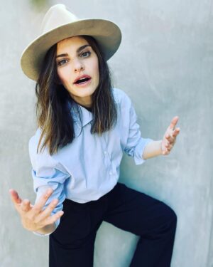 Sara Gilbert Instagram - me saying “look! i’m wearing a hat! and also! hi! do you like wanna come to the last night of my residency at @thehotelcafe monday 8/29 @ 7pm. it’s gonna be something… @reallindaperry @thesaragilbert @andrewleeds @rachelgould27  link for tickets in my bio! oh! and special guests @iamtimbagley @noahweisberg  @karoline_menezes__ @dereksteincello and more!!! 📸 @amandademme  love, me