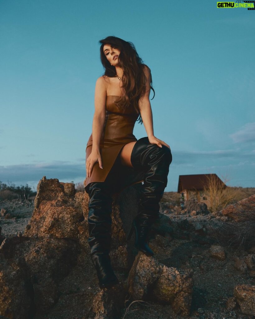 Serinda Swan Instagram - This shoot was taken in the desert at Mojave Moon Ranch, and right as the sun was setting we ran to the top of this mountain for the most beautiful light Definitely not easy in these boots, but the picture was well worth it. 😂 Exclusive for @ladygunn Photography: Valerie Burke @burkephotography Stylist: Sofia Popkova @iamsofiapopkova @stylebysofiapopkova Make Up: Marlena Von Kazmier @marlenavonkazmier_mua Hair: Olya Romanenko @o.r.hair Styling Assist: Anastasia Buriak @aintsweetlikesuga & Oksana Masalyko @oxanamas Wearing: Leather dress: @attickoncept Boots: @berhasm_global - @tata_la Necklace: @attickoncept