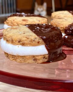 Sohla El-Waylly Instagram - An oldie but goodie cookie! Sweet, salty, sticky, crunchy, and chocolate-y, these ✨Pretzel & Potato Chip Moon Pies✨ deserve your attention every holiday! Perfect for when you kind of want a project, as some assembly is required, but don’t want to bother with piping bags and icing. Original full recipe on Bon Appetit dot com 1 ¾ cup (219g) all-purpose flour ½ cup (100g) sugar 1 cup (60g) lightly crushed pretzels 1 cup (40g) lightly crushed potato chips ½ tsp. kosher salt 16 Tbsp. (228g) unsalted butter, cut into pieces 18 jumbo marshmallows 4 oz. (113g) dark chocolate, roughly chopped 1 Tbsp. refined coconut oil pretzel or flaky salt 1. In a food processor, pulse together flour, sugar, pretzels, potato chips, salt, and butter until the mixture holds together in clumps. Dump the dough out onto a clean surface and knead to bring together. 2. On a lightly floured surface, roll the dough until just over 1/8-inch thick. (If the dough feels very soft, chill before proceeding) 3. Using a floured 2-inch round cutter, cut out cookies, transferring to a parchment lined baking sheet. Gather the scraps and repeat. Bake at 350F until lightly browned, 11-13 minutes. 4. Remove from oven, let cool 5 minutes and transfer half the cookies to a wire rack to cool. Flip over the cookies remaining on the baking sheet and top each with a marshmallow. Bake until marshmallow is softened, just beginning to puff, but not brown, about 4 minutes. Top with the reserved cookies and allow the weight of the cookie to gently spread the marshmallow to the edges. (The cookies won’t appear to stick initially, but they will as they cool.) Set aside to cool fully, at least 1 hour. 5. Melt the chocolate and oil, then dip half of each sandwich cookie in chocolate and sprinkle with salt. Chill cookies in fridge to harden then store in an airtight container for up to 2 weeks.