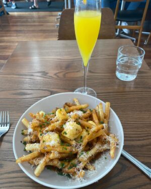 Suzanne Paul Instagram - Great start to the day - French Fries with gravy and melted cheese and a Mimosa at @tobiponsonby  so delicious!