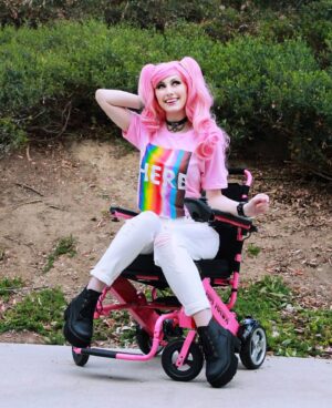 Tara-Nicole Azarian Instagram - My name is Tara and I am HERE 🏳️‍🌈
●●●●
Happy Pride Month! 🏳️‍🌈 Hi, I'm Tara and I'm bisexual. I am also demisexual. I am so very blessed to have a family who brought me up in an environment where I KNEW that I was loved unconditionally. We say I love you every chance we get. We hug...a lot. Mom has always told me that she will love me even when I have trouble loving myself. ❤ She has always made me feel safe. Society, not so much. Because I am in a relationship with a man ➡️ EVERYONE would tell me that meant I was straight. I have always known to whom I was attracted and it's both females and males. Being in a relationship that appears heterosexual doesn't mean I am just because it makes you feel more comfortable. 🏳️‍🌈 No one should have to hide who they are, including me. 🏳️‍🌈
●●●●
@hottopic has partnered with @trevorproject this month and proceeds from this collaboration Tee shirt design go to the Trevor Project which was
founded in 1998 and is the leading national organization providing crisis intervention and suicide prevention services to  (LGBTQA ) young people under 25. Their services are always free. 🏳️‍🌈
●●●●
#htfxpride #HTFanatic #hottopic #sponsoredbyHT #pridemonth #loveislove #disabledcosplayer #disabledmodel #disabledandhot #disabilitypride #ambulatorywheelchairuser #ehlersdanlossyndrome #mastcellactivationsyndrome #disabledandcute #officialtaracosplay #wheelbodiesarebeautiful #scoliosis #dysautonomia