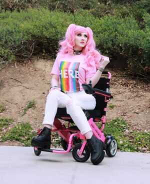 Tara-Nicole Azarian Instagram - My name is Tara and I am HERE 🏳️‍🌈
●●●●
Happy Pride Month! 🏳️‍🌈 Hi, I'm Tara and I'm bisexual. I am also demisexual. I am so very blessed to have a family who brought me up in an environment where I KNEW that I was loved unconditionally. We say I love you every chance we get. We hug...a lot. Mom has always told me that she will love me even when I have trouble loving myself. ❤ She has always made me feel safe. Society, not so much. Because I am in a relationship with a man ➡️ EVERYONE would tell me that meant I was straight. I have always known to whom I was attracted and it's both females and males. Being in a relationship that appears heterosexual doesn't mean I am just because it makes you feel more comfortable. 🏳️‍🌈 No one should have to hide who they are, including me. 🏳️‍🌈
●●●●
@hottopic has partnered with @trevorproject this month and proceeds from this collaboration Tee shirt design go to the Trevor Project which was
founded in 1998 and is the leading national organization providing crisis intervention and suicide prevention services to  (LGBTQA ) young people under 25. Their services are always free. 🏳️‍🌈
●●●●
#htfxpride #HTFanatic #hottopic #sponsoredbyHT #pridemonth #loveislove #disabledcosplayer #disabledmodel #disabledandhot #disabilitypride #ambulatorywheelchairuser #ehlersdanlossyndrome #mastcellactivationsyndrome #disabledandcute #officialtaracosplay #wheelbodiesarebeautiful #scoliosis #dysautonomia
