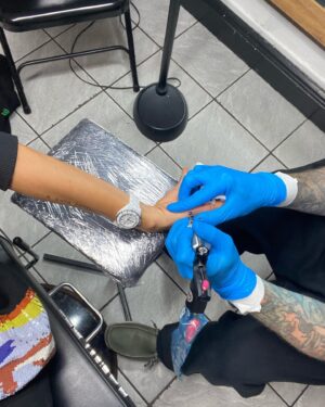 Thandiwe Newton Instagram - NOW I’m home. Got my post @westworldhbo Season 4 ink done by my homeboy @miles_chappers 

Every milestone is marked by Miles. 

Booker came along to watch. He designed a tattoo for me too, thank you baby. 

@frithsttattoo ☠️ go hard or go home

Xx Thandiwe

Oh yeah - wearing @ashish dope hoodie and @chanelofficial watch @bella_freud sparkly leggings that you can’t see 😋
And @sacaiofficial boots that I want grafted onto my ankles like permanent hooves.

I pissed IN the f***ing toilet 🙏🏽