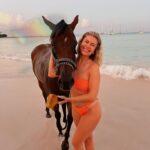 Victoria Spence Instagram - The most special morning 🥹🫶🏻 Every morning the race horses are taken to the beach at sunrise to roll in the sand, have a swim and get bathed. 🌅 We got talking to one of the guys and he asked if I wanted to get in, and next minute his hands were out ready to push me onto the horse😅 my heart was in my mouth at first, but it was the most precious experience! I’ll literally never forget it🥹 To top it off, he told me the horse was called Jerusalema after the song, which if you’ve been here a while, you’ll know my obsession with that song- one of my faves ever!🥲 I’ll remember this morning forever ❤️ @mikesingym can we get a horse?! #barbados#corememory