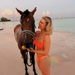 Victoria Spence Instagram - The most special morning 🥹🫶🏻 Every morning the race horses are taken to the beach at sunrise to roll in the sand, have a swim and get bathed. 🌅 We got talking to one of the guys and he asked if I wanted to get in, and next minute his hands were out ready to push me onto the horse😅 my heart was in my mouth at first, but it was the most precious experience! I’ll literally never forget it🥹 To top it off, he told me the horse was called Jerusalema after the song, which if you’ve been here a while, you’ll know my obsession with that song- one of my faves ever!🥲 I’ll remember this morning forever ❤️ @mikesingym can we get a horse?! #barbados#corememory