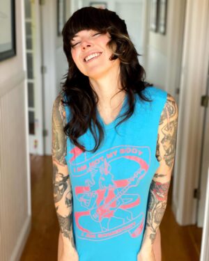 Alexis Krauss Instagram - I am not my body. I am somebody.

This shirt hits especially hard today and not just because I love sexy queer unicorn bass players 🦄 @dreamwife 

The words below are imperfect and distracted. After all, I am drafting them while my five month old son suckles from my breast, cooing and smiling. It’s pretty hard to focus…

As he nourishes himself from my body, the same body that grew him and birthed him (!!!) I daydream about him growing up in a world where the bodies of women and other marginalized beings are respected and celebrated. A world where all people have agency and choice over how they want to show up and experience life. 

On this International Women’s Day I grieve for the mothers in Gaza. I grieve for the trans community. I grieve for the victims of sexual violence. I grieve for the humans unable to access safe abortions. I grieve for anybody who doesn’t feel safe and protected.

Over the years the way I think about this day has evolved. Now being a mother, and raising a privileged white male, I feel an even greater responsibility to empower those who have historically been disempowered.

Despite all of the pain, I want to celebrate those incredible humans out there who are fighting to exercise choice over their bodies. I want to celebrate the scars of childbirth and the scars of top surgery. I want to celebrate the titties, however saggy and sucked on they might be. I want to celebrate the stretch marks, the folds, the pouches and the pussies.

Get out there and take up all the space you can. Get out there and disrupt. Cause lots of trouble. Get out there and be your most colorful, loudest, queerest, fiercest and sexiest unicorn.

Thanks for indulging me in this last minute pants-less nap-time photoshoot  @chris_vultaggio 🥰
