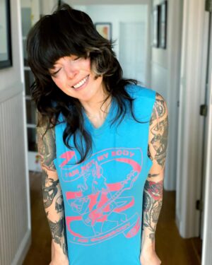 Alexis Krauss Instagram - I am not my body. I am somebody.

This shirt hits especially hard today and not just because I love sexy queer unicorn bass players 🦄 @dreamwife 

The words below are imperfect and distracted. After all, I am drafting them while my five month old son suckles from my breast, cooing and smiling. It’s pretty hard to focus…

As he nourishes himself from my body, the same body that grew him and birthed him (!!!) I daydream about him growing up in a world where the bodies of women and other marginalized beings are respected and celebrated. A world where all people have agency and choice over how they want to show up and experience life. 

On this International Women’s Day I grieve for the mothers in Gaza. I grieve for the trans community. I grieve for the victims of sexual violence. I grieve for the humans unable to access safe abortions. I grieve for anybody who doesn’t feel safe and protected.

Over the years the way I think about this day has evolved. Now being a mother, and raising a privileged white male, I feel an even greater responsibility to empower those who have historically been disempowered.

Despite all of the pain, I want to celebrate those incredible humans out there who are fighting to exercise choice over their bodies. I want to celebrate the scars of childbirth and the scars of top surgery. I want to celebrate the titties, however saggy and sucked on they might be. I want to celebrate the stretch marks, the folds, the pouches and the pussies.

Get out there and take up all the space you can. Get out there and disrupt. Cause lots of trouble. Get out there and be your most colorful, loudest, queerest, fiercest and sexiest unicorn.

Thanks for indulging me in this last minute pants-less nap-time photoshoot  @chris_vultaggio 🥰