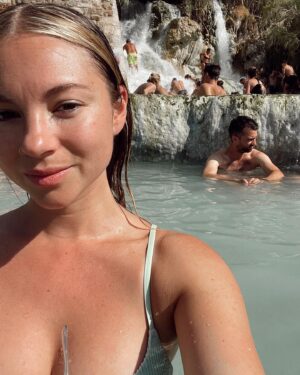 Allie Gonino Instagram - It’s not so easy to get to Saturnia, a small village in the middle of Toscana. Surrounded by rolling hills, olive tree farms, and vineyards nestled in deep valleys, is Le Cascade Di Saturnia. This is a sulfuric thermal spring where the water is as warm as a bath, and contains so many essential minerals. If you look behind me in the second photo, you can see the waterfalls that flow into the pools. I sat in meditation for nearly 40 minutes under one of the high pressure areas and allowed myself to just receive a deep, cathartic massage from Mother Nature. I can’t remember the last time I felt so relaxed and nurtured. Traversing the pools full of people takes a bit of balance and mindfulness, but once you’re in, you’re in. This moment was definitely worth the trip.