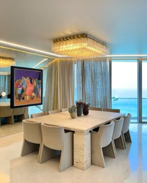 Andrés Mercado Instagram - Dinning in heaven starts with uninterrupted ocean views and off course this chic art piece from the most important Colombian artist of all times, Fernando Botero. Along this perfection we customized an oversized  marble table in travertine and add some softness with the velvet chairs, we can not missed the flower arrangements by @lafloreria.atelier on top of the Vanitas Set Rubber Vase by studio b severin Germany, under the light of this majestic 1960s flush mount thanks to @1stdibs .