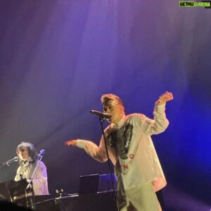 Anthony Wong Yiu-Ming Instagram - 謝謝這位朋友用心的書寫、記錄。🙏🏽🙏🏽🙏🏽🙏🏽

Posted @withregram • @ginnyaya 20240405 黃耀明邊走邊唱新北

黃耀明邊走邊唱一年多，唱回了台灣。和23年首站台北Legacy破釜沈舟的壯烈相比，今晚的明哥和觀眾感覺都更自在更不拘謹了些。和Jason、Veegay三人一身白衫亮相，超正超有型！

開場以黎小田的經典作品，致敬緬懷了香港的風華年代，然後電子節拍一下，金曲連發，最壞的時代裡共度患難的嬉戲，每天美麗每天燦爛，就算插翼難飛，這是明哥歌曲裡的華麗頹靡。M、V、J三人，無需影像視覺投影，便以音樂燈光在舞台上構築了一個豐盛的城邦。

Talking時黃耀明說他年紀大了，要看提詞機，有老花信上字寫太小看不清。是，他有了魚尾紋，但眼神依然清澈透亮。這次重返台灣，歌單有不少變化，他唱了新歌《石沈大海》，也唱了幾首驚喜的曲目。《如果你愛我》、《帶不走》深情叫人融化。

還記得23年台北場次，明哥還客氣的堅持在台灣開唱要入境隨俗，講著他不熟練的中文。這次，很開心他自如自在，輕鬆地切換粵語、國語，不需要顧忌什麼。作為台灣人，深深希望台灣能一直這樣，接納來自香港、中國，還有世界各地的樂迷。我們都不知道哪一天黃耀明可以在香港演出，但希望台灣，能夠做一個應許之地，繼續讓人說想說的話，唱想唱的歌。

到了演唱會後段，在有高雄港口哀鳴聲的《港都夜雨》和《望你早歸》歌曲裡，漂泊異鄉的人，在故鄉思念的人，用台語傾訴的心聲，自然呼應了接下來的《住》和《今天世上所有地方》——他鄉有一日可以成為故鄉嗎？「從此安居哪裡，你在哪裡」、「繼續看、一點光，總會找到方向。」明哥幾次激動而難以自已，全場自發點亮的燈海，台灣與香港，過去與現在的種種念想彼此共鳴。

所以，親愛的瑪嘉烈，慘綠青年如你也一定可以捱得到新天地，成為一個厲害的普通人⋯明哥唱給年青人，也是唱給自己，唱給香港人，也唱給所有渴望自由的靈魂—可以的，我們可以的。「You shoot me down, but I won‘t fall，I am titanium」 

安可曲呼應開場，我們也重溫了顧家煇。不論時代多壞，這些美好的旋律將繼續活在人們心中，如同璀璨華麗的香江。黃耀明不僅把自己的歌帶到世界，更要在旅途上把香港最美好的瑰寶分享給世界。

一如潘源良寫的：「繼續唱，繼續找，總會找到方向。」

#黃耀明  #黃耀明邊走邊唱新北 #黃耀明邊走邊唱
