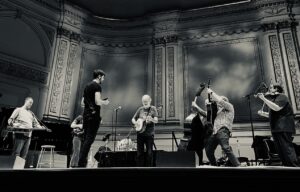 Béla Fleck Instagram - Here are some "ReFlecktions" Jen Hughes sent me after the show at @carnegiehall. 

• The way Béla met Bruce Hornsby and dove deep together into the depths of “The Way It Is” and danced with each other to bring it into a life of its own: a way it has never been played before. It was stunning. It sounded so good; I practically wept. So amazing to see two soulmates create before one’s very eyes - - and with such a beautiful tune.
 
• Similarly, with Zakir Hussain – a Béla brother from another mother. Those two have such a great connection; it just shines and resonates. When they were trading “riffs” with each other, it was so fun for the audience, but also jaw-dropping. Again, witnessing masters at work - - but, also, at play because it appears they so enjoy playing with each other.
 
• The clarinetist! Anat Cohen, for crying out-loud! What a find and such a great executed idea to have her play with you. She is cut from the same cloth - - a rare thing! Her on Juno, in particular, was pure joy in action.
 
• Rhapsody. Rapt: the whole hall! I knew I would love it. I had not seen it live before: just some pieces during some of Béla’s solos, never with a symphony. It was striking how much I loved hearing it live with a symphony. It was powerful, riveting, and perfectly delightful! And, absolutely masterful during the part where the symphony fell away and Béla played virtually all of their parts on his banjo alone. Literally breathtaking. Bravo. Also, the talent of those Jacobsen brothers. And, how uplifting to see Edgar Meyer’s son in the orchestra. I suspect Béla has known him all his life. Sweet. Awesome that Béla wore that jacket for the Rhapsody segment of the show. That jacket is the best.
 
• My Bluegrass Heart. I will never get enough of it. Legendary playing by all. Slippery Eel. Whoa! I think I broke a sweat it was moving so fast. Béla slayed it. Rhapsody in Blue(grass) was to die for. The ever-beautiful Big Country. The addition of Zakir’s percussion was phenomenal, and every time Michael Cleveland played the part that I always think of as when the angels sing or the eagles soar my heart skipped a few beats.