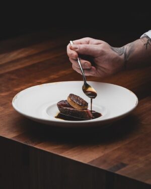 Björn Frantzén Instagram - Duck “périgourdine”, dates, caramelized citrus & foie gras.

Challans duck, from France’s Loire region, that we dry-age, brush with its own rendered fat, and bake over the birch wood fireplace🔥Topped with grilled Medjool date filled with an emulsion of caramelized citrus, hazelnut oil, and foie gras fat, and served with Périgourdine sauce @restaurantfrantzen