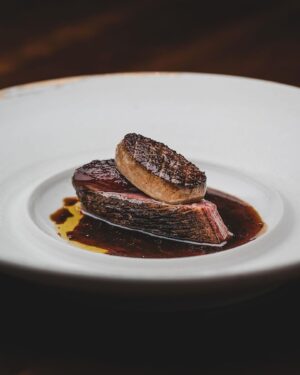 Björn Frantzén Instagram - Duck “périgourdine”, dates, caramelized citrus & foie gras.

Challans duck, from France’s Loire region, that we dry-age, brush with its own rendered fat, and bake over the birch wood fireplace🔥Topped with grilled Medjool date filled with an emulsion of caramelized citrus, hazelnut oil, and foie gras fat, and served with Périgourdine sauce @restaurantfrantzen
