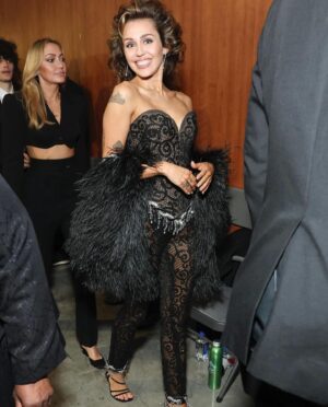Bob Mackie Instagram - @mileycyrus wears a black beaded fringe, lace bustier and pants, with a beaded fringe trim feather shrug. This look pictured backstage at The Grammys, is from Bob Mackie’s 2002 ‘To Broadway with Love’ collection. 

Styled by: @bradleykennethstyle 

#BobMackie #MackieMagic #MileyCyrus #Grammys2024